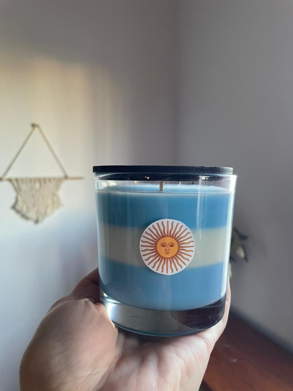 Vela artesanal de la línea Svelas con diseño de bandera argentina para ambientación de interiores.